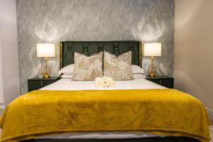 SandtonにあるEagle of Kawele 3-bedroom villaのベッドルーム1室(黄色の毛布とランプ2つ付)
