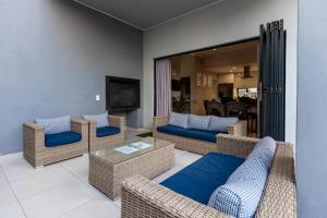 a living room with wicker furniture and a television at Eagle of Kawele 3-bedroom villa in Sandton