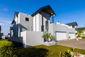 una casa blanca con techo negro en Eagle of Kawele 3-bedroom villa, en Sandton