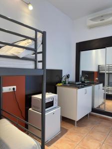 a room with a bunk bed with a kitchen and a counter at #11 Mini ESTUDIO FAMILIAR AYAMONTE in Ayamonte