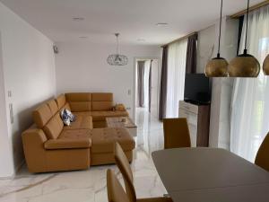 ein Wohnzimmer mit einem Sofa und einem Tisch in der Unterkunft Luxury Apartments in Balatonalmádi, Almádi Lux Apartman III - Pure Gold in Balatonalmádi