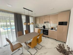 eine Küche mit einem Tisch und Stühlen im Zimmer in der Unterkunft Luxury Apartments in Balatonalmádi, Almádi Lux Apartman III - Pure Gold in Balatonalmádi