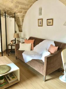 ein Wohnzimmer mit einem Sofa und einem Tisch in der Unterkunft Petit loft sur jardin en centre-ville in Uzès
