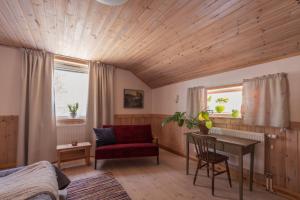 1 dormitorio con techo de madera, escritorio y silla en Kalix Riverside inn, Farm timbering en Kalix