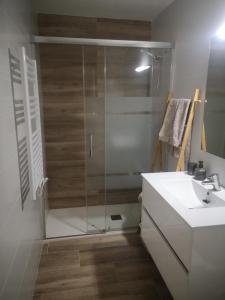 a bathroom with a glass shower and a sink at Apartament LA SAL in Pineda de Mar