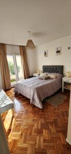 a bedroom with a large bed and a wooden floor at Kelly House in Mendoza
