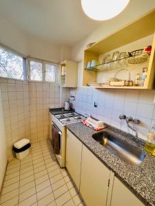 a small kitchen with a sink and a stove at Luminoso departamento con vista! in Córdoba