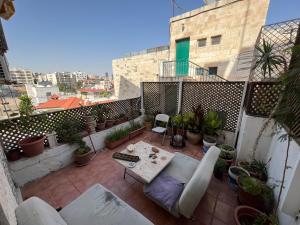 een balkon met een tafel en veel planten bij Comfy place in Amman