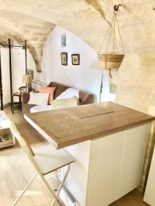 eine Küche und ein Wohnzimmer mit einem Tisch und einem Sofa in der Unterkunft Petit loft sur jardin en centre-ville in Uzès