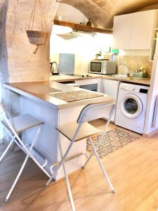 eine Küche mit einer Theke und einer Waschmaschine in der Unterkunft Petit loft sur jardin en centre-ville in Uzès