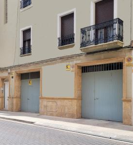 a building with three garage doors on a street at La Casa Alandí con garaje privado in Sagunto