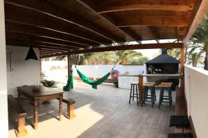 d'une terrasse avec un hamac, une table et des chaises. dans l'établissement Oasis en Lanzarote, à Costa Teguise