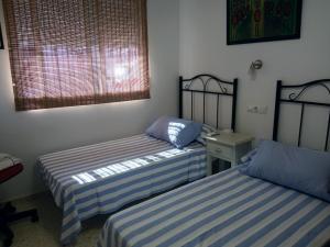 a room with two beds and a window at Apartamento San Miguel in Baena