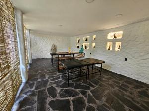 a room with two tables and a wall with paintings at CASA NDOMI TEPOZ in Tepoztlán