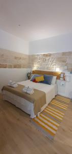 a bedroom with a large white bed and a rug at JACARANDA in Conversano