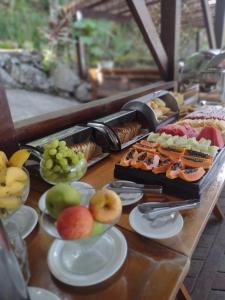 una mesa cubierta con platos de comida y fruta en Pousada Camarote Itaipu, en Niterói