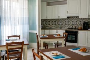 - une cuisine avec des placards blancs, une table et des chaises dans l'établissement Villa Vilù, à Bellosguardo