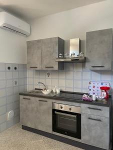 eine Küche mit Spüle und Herd oberen Backofen in der Unterkunft La Vecchia Chiassaia (mare/montagna) in La Pescaia