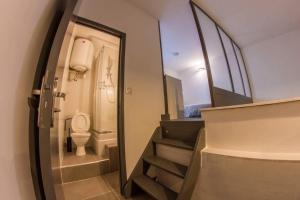 a small bathroom with a toilet and stairs at Joli loft atypique - Métro Valmy in Lyon