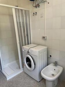 eine Waschmaschine im Badezimmer neben einer Toilette in der Unterkunft La Vecchia Chiassaia (mare/montagna) in La Pescaia