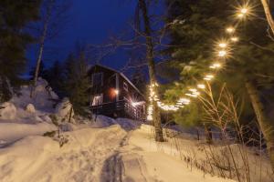 una cabaña de madera en la nieve por la noche en Kalix Riverside inn, Farm timbering en Kalix