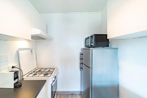 una cucina con frigorifero e piano cottura di Studio cosy - Villeurbanne Vaulx en Velin a Villeurbanne