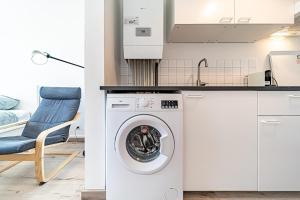 a kitchen with a washing machine and a chair at Studio cosy - Villeurbanne Vaulx en Velin in Villeurbanne