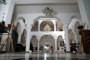 a large room with white columns and a chandelier at Riad Ras Lafaa in Safi