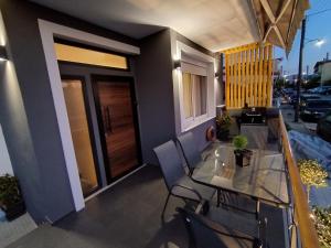 a balcony with a glass table and chairs on a building at AEGEAN SUITES in Keramoti