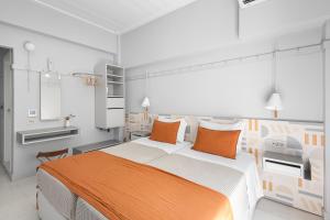 a bedroom with a large bed with orange pillows at Argonauta Hotel in Parikia