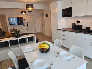 eine Küche mit einem Tisch und einer Schale Bananen drauf in der Unterkunft Anomis Infinity Pool & SPA Resort Sea-View in Mamaia Nord – Năvodari
