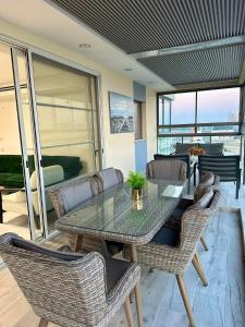 a dining room with a glass table and chairs at Suite In White in ‘Akko