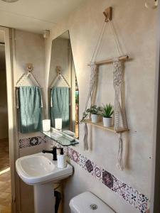a bathroom with a sink and a mirror and a toilet at Coqueta casita Playa Palmar-300m-Zoco in El Palmar