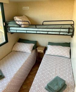 2 camas en una habitación con 2 literas en Coqueta casita de playa en el Palmar, en El Palmar