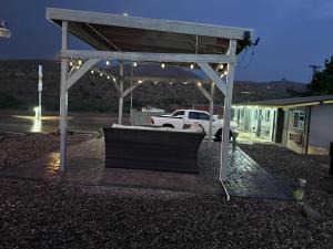 a bench under a pavilion with lights in a parking lot at Belle Aire Motel in Globe +11 photos