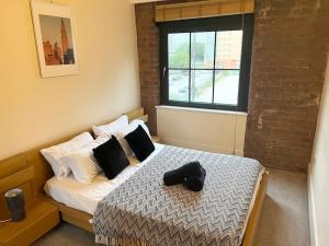 Un dormitorio con una cama con zapatos negros. en City Center 2 bedrooms Apartment, en Mánchester