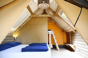 a bed in a tent with a ladder in a room at Camping Porto Sosàlinos in Cala Liberotto