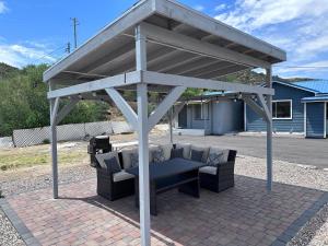 a pergola with two chairs and a bench on a patio at Belle Aire Motel in Globe