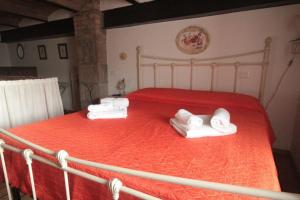 Un dormitorio con una cama roja con toallas. en 14 Toscana da Vilma, vacanza, piscina - CASA PRIVATA en Castel del Piano