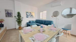 sala de estar con mesa y sofá azul en Apartamentos TrianaSol en Sevilla