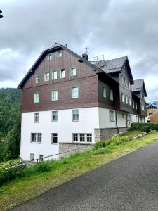 um grande edifício castanho e branco ao lado de uma estrada em Family Ski apartment em Spindleruv Mlyn