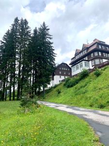 uma casa no topo de uma colina com uma estrada em Family Ski apartment em Spindleruv Mlyn