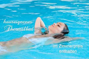 a young woman swimming in a swimming pool at Schloss Kirchham Appartement - & Wellnessanlage in Kirchham