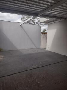 an empty parking garage with a white wall at Nossa Casa Ambiente Familiar in Águas de São Pedro