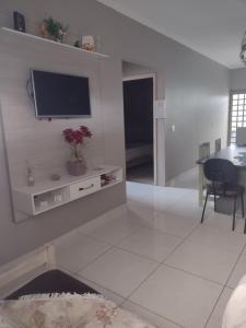 a living room with a flat screen tv on the wall at Nossa Casa Ambiente Familiar in Águas de São Pedro
