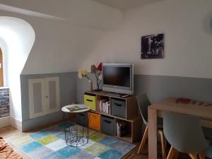 a living room with a tv and a table at Appartement cosy pour une pause sereine et chaleureuse in Le Mont-Dore