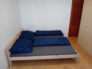 a bed in a room with blue pillows on it at Statek in Veverská Bítýška