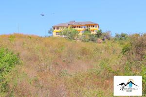 Rocky river falls resort في Thika: منزل على قمة تل مع العشب