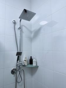 a shower in a bathroom with a light on the ceiling at Studio by the river in HaGoshrim