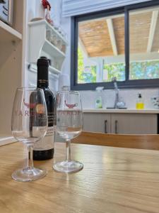 two wine glasses sitting on a table with a bottle of wine at Studio by the river in HaGoshrim +29 photos